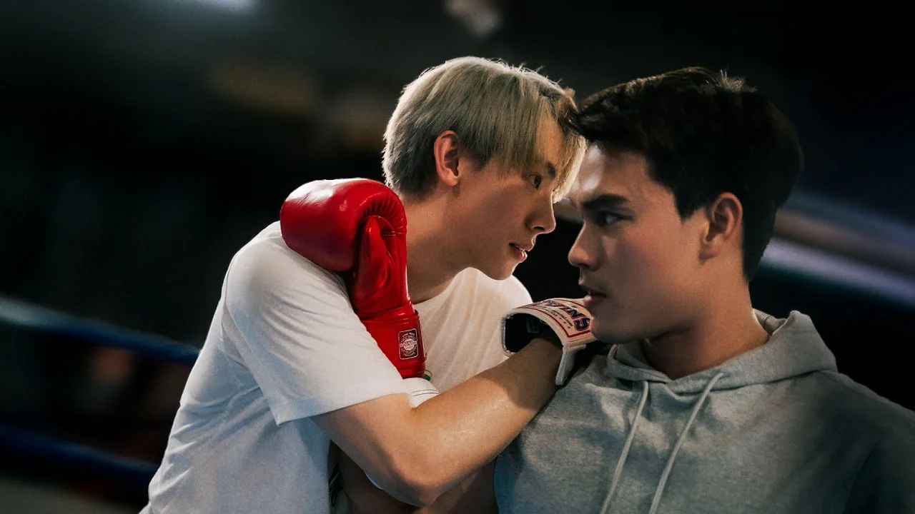 Two young men face each other closely inside a boxing ring, with one wearing red boxing gloves resting his arm on the other's shoulder, creating an intense and intimate moment from the Hook Your Heart official pilot.