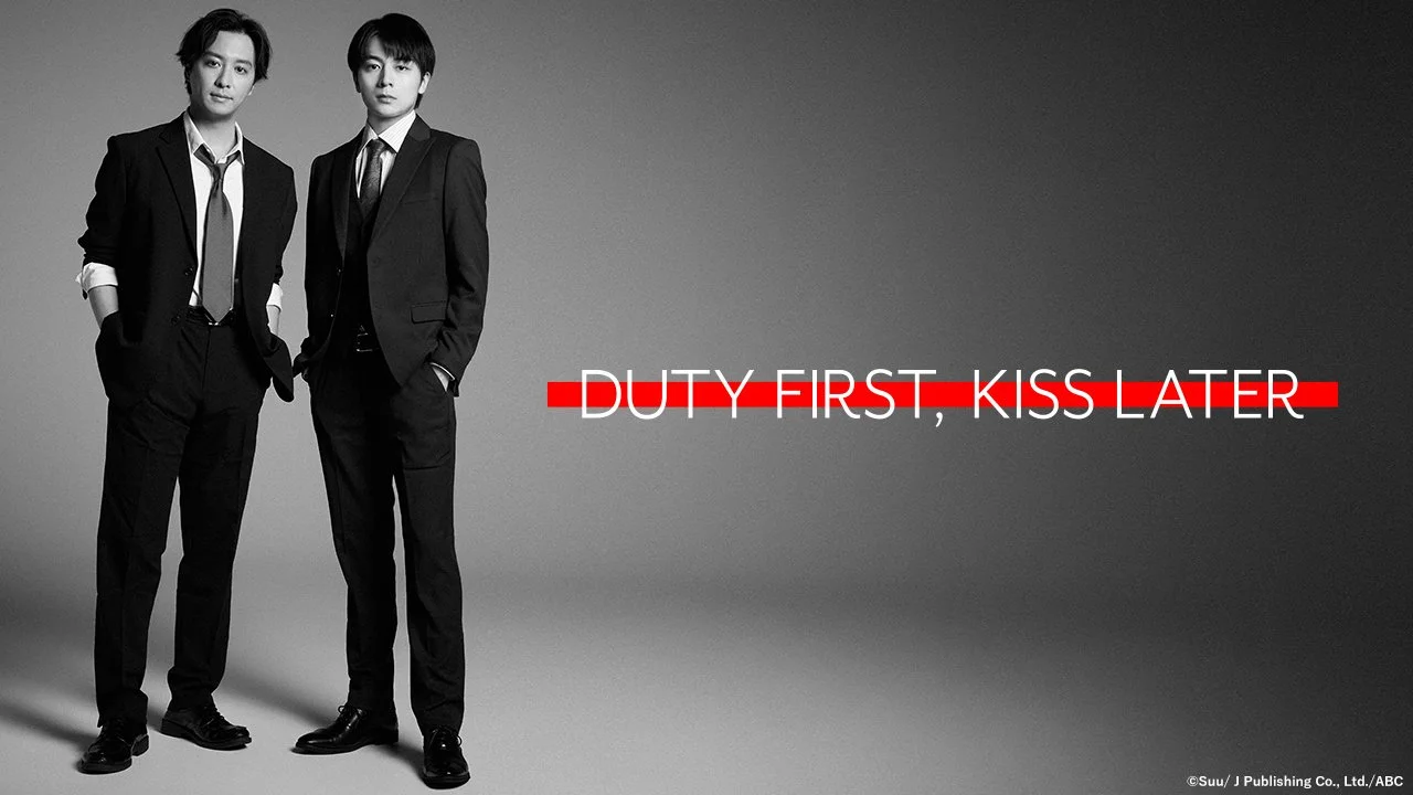 Shu Watanabe and Ryu Saito stand in suits beside the title “Duty First, Kiss Later” in the Japanese BL series’ black-and-white key visual.