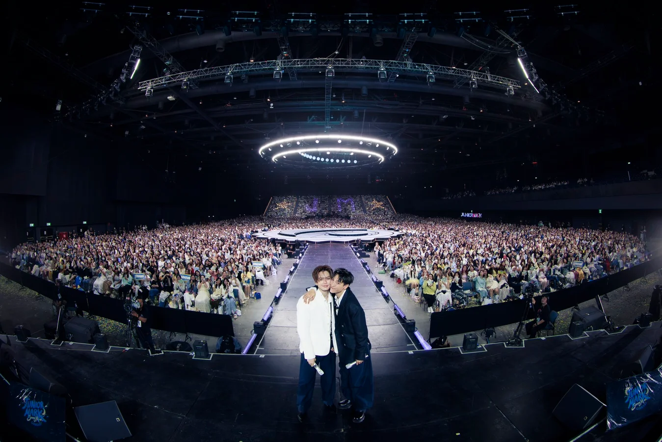 Junior Panachai and Mark Jiruntanin pose together onstage in front of the audience at the JUNIOR MARK SunnyMoon Concert at BITEC Live in Bangkok.