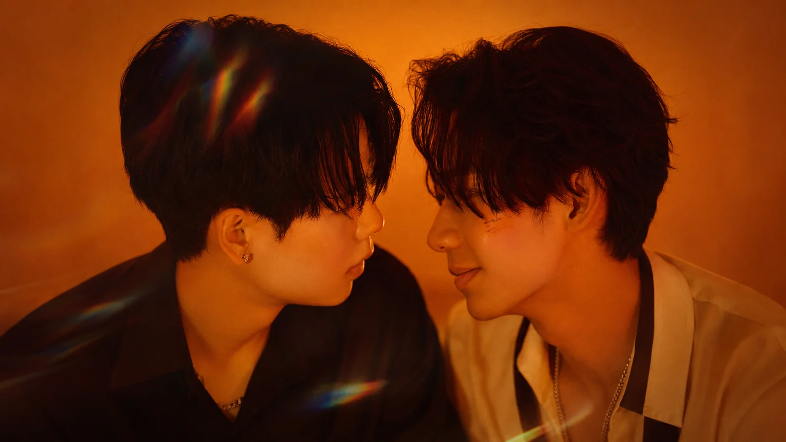 Orion and DayDay face each other beneath warm orange lighting in a promotional image for the Chinese BL series Kiss or Kill.