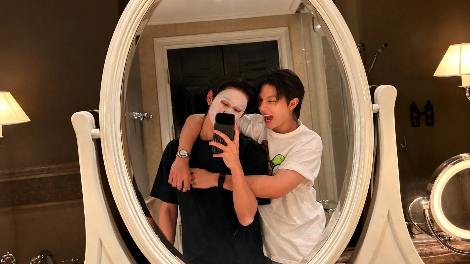 William Jakrapatr hugs Est Supha from behind as the pair pose for a playful mirror selfie following William’s recent travels with LYKN.